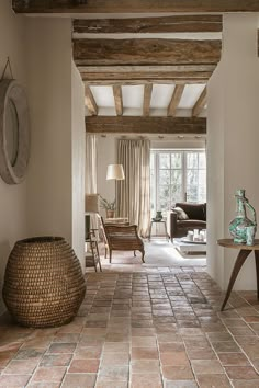 a living room filled with furniture and a large vase on top of a tiled floor