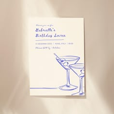 a blue ink drawing of a martini glass on top of a birthday card with the words happy birthday