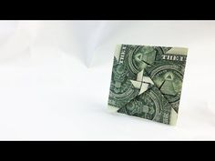 a folded dollar bill sitting on top of a white surface