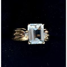 This is part of Chairish’s Fine Jewelry assortment.  DESIGNER CLYDE DUNEIER, Aquamarine & Diamond 14k Yellow Gold 2.7 Carat Ring. Ring Size: 6.5 in.  Stamped 14K, set with pale colored aquamarine. Weight of Ring: 4.9 grams Classic Diamond Gemstone With Center Stone, Elegant 14k Gold Baguette Cut Topaz Ring, Timeless Emerald-cut Topaz Ring With Prong Setting, Timeless Emerald Cut Topaz Ring With Prong Setting, Classic Baguette Cut Topaz Promise Ring, Emerald Cut Diamond Gemstone For Formal Occasions, Emerald Cut Diamond Gemstones For Formal Events, Gold-toned Gemstones With Prong Setting For Anniversary, Elegant Yellow Gold Emerald-cut Topaz Ring