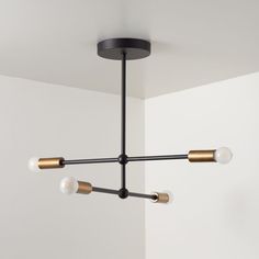 a black and gold chandelier hanging from the ceiling in a room with white walls