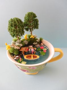 there is a small boat in the water with trees and flowers growing out of it