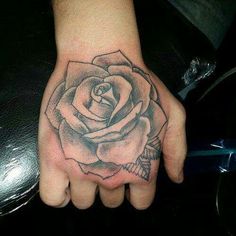 a hand with a rose tattoo on it