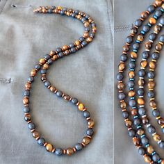 Introducing the "Eye of the Tiger" men's beaded necklace, a striking piece that combines the rugged elegance of natural stones with the bold style you seek. This necklace is meticulously handcrafted, featuring a powerful trio of Tiger Eye, Lava, and Hematite stones, each bead measuring a perfect 6mm. The Stones: Tiger Eye: Known for its captivating golden to reddish-brown hues, Tiger Eye is a stone of protection and grounding. It brings sharpness to one's inner vision and aids in manifesting wil Men Beaded Necklace Ideas, Black Ninja, Tiger Eye Necklace, Mens Beaded Necklaces, Mens Necklace, Trending Necklaces, Brown Necklace, Beaded Jewels, Hematite Stone