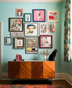 a room with blue walls and various framed pictures on the wall, including a cat