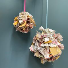 two paper balls hanging on the wall with one ball covered in torn up papers and another made out of old magazines