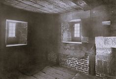 an old room with brick walls and two windows