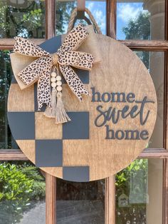 a wooden sign that says home sweet home with a bow on the front and side