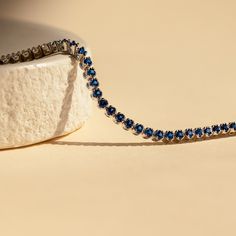 Make a shimmering statement with our Blue Sapphire Diamond Tennis Bracelet. Elegant and dainty, it adds the perfect bold, finishing touch to your outfit for special occasions like anniversaries or weddings. A minimalist accessory sure to shine and a dazzling symbol of “something blue” for brides. Material: High Quality Solid 925 Sterling Silver Finish: Sterling Silver ∙ 18K Gold Clasp: Box clasp and side prong closure Featuring a 6 inch (ONE SIZE) ~3mm Tennis Bracelet with half CZ Sapphire and h