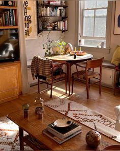 a living room filled with furniture and a wooden table in front of a tv mounted on a wall