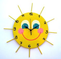 a yellow clock with blue eyes and a smile on it's face is shown