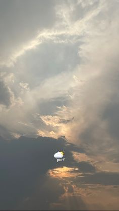 an airplane flying in the sky with clouds and sun peeking through it's center