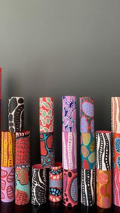 many different colored vases lined up on a table