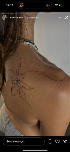 the back of a woman's shoulder with a flower tattoo on it