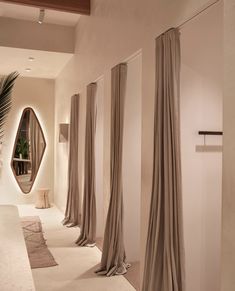 an elegant hallway with beige drapes and mirrors