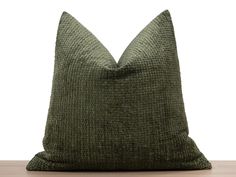 a green pillow sitting on top of a wooden table