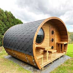 a large wooden barrel like structure in the grass