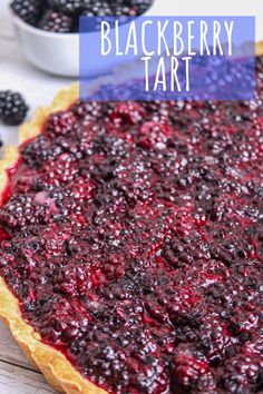 blueberry tart in a pie crust with berries around it