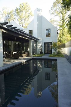 a house with a pool in front of it and an outdoor lounge area next to it