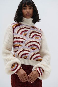 This bold sweater is made from a beautiful blend of alpaca and cotton, expertly crafted for sustainable fashion and ultimate comfort. This hand-knit masterpiece features a rich design, with voluminous sleeves, making it the perfect statement piece for the colder seasons. It features a high, ribbed turtleneck that offers cozy warmth while elongating the neck for a sophisticated silhouette. The natural softness of alpaca paired with the durability of cotton ensures warmth, breathability, and a uni Chic Multicolor Winter Sweater, Rich Design, Voluminous Sleeves, Alpaca Sweater, High Waist Fashion, Ribbed Turtleneck, Cardigan Top, Cold Season, Crochet Details