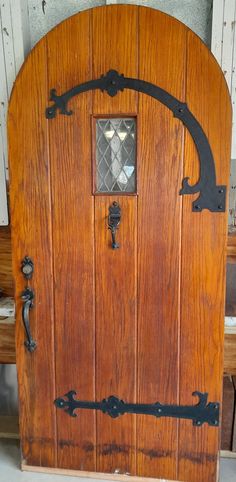 an old wooden door with wrought iron handles and glass inserts on the top part