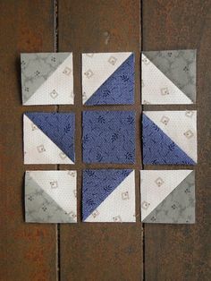 four pieces of fabric are arranged in the shape of a triangle on a wooden surface