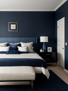 a bedroom with blue walls and white bedding