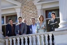 the cast of suits and ties are standing on a balcony