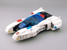 a white and blue toy car on a gray surface with red, white, and blue lights