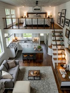 a living room and kitchen with stairs leading to the upper floor, above which is a loft bed