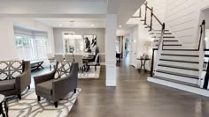 a living room filled with furniture next to a stair case in a large open floor plan