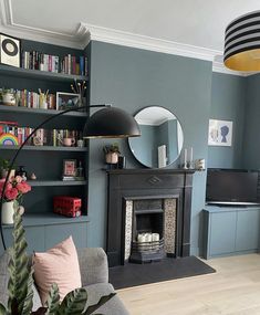 a living room filled with furniture and a fire place in front of a tv mounted on a wall