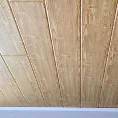 a close up view of wood planks on the ceiling in a room with white walls