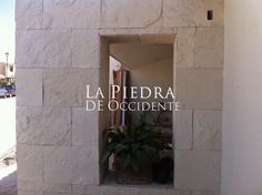 an open window on the side of a building with a potted plant in it