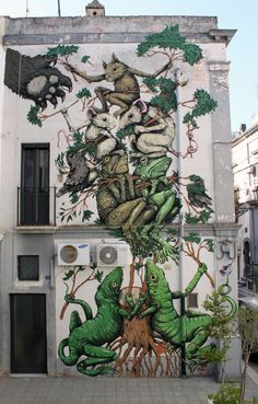 a large mural on the side of a building with animals and trees painted on it