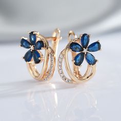 Do you want to show everyone that you're a luxuriously fashionable woman? These Blue Zircon Floral Earrings are exquisitely beautiful earrings that will impress everyone. The blue flower design is a unique style that makes these earrings look very expensive. Buy these for anniversaries, birthdays, holidays, or just because. Specifications: Side Stone: Natural White Zircon Main Stone: Blue Zircon Size: 17mm * 14 mm Metal: 585 (14kt) Gold Vermeil 🚐Delivery: 2-3 weeks Elegant Flower-shaped Hoop Earrings For Anniversary, Blue Elegant Design Earrings For Anniversary, Elegant Blue Cluster Earrings As Gift, Elegant Blue Cluster Earrings For Gift, Blue Flower Shaped Earrings For Formal Occasions, Blue Flower-shaped Formal Earrings, Formal Blue Flower-shaped Earrings, Blue Formal Flower-shaped Earrings, Blue Cubic Zirconia Earrings With Elegant Design