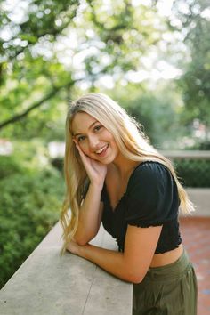 a beautiful blonde woman leaning on a wall