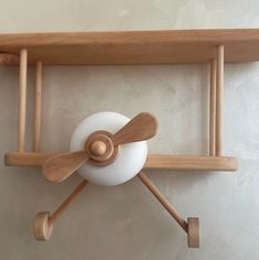 a wooden shelf with a white ball and two wood sticks attached to the top of it