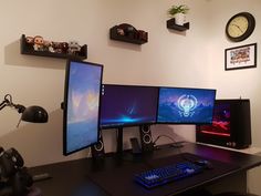 three computer monitors sitting on top of a desk next to a keyboard, mouse and monitor