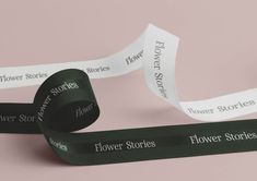 two rolls of black and white flower stories ribbon on a pink background with the words flowers stories written across them