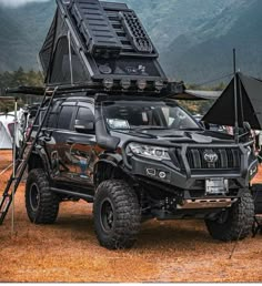 a black truck with an open top on it's flatbed in front of mountains