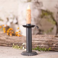 a candle holder with a single lit candle on it