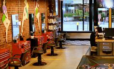 the inside of a barber shop with lots of chairs