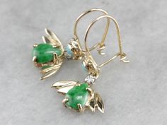 "We love the color in these vintage drop earrings, the bright green jade centers with the winged gold backs gives the appearance of a stylized bat, the soft turquoise gemstones, and small sparkling diamonds add a pop of color and flash to these fantastic drop earrings! Metal: 14K Yellow Gold Gem: Jade Gem Measurements: 7 x 5 mm, Pear Cut Accents: 2 Turquoise, 2 Diamonds totaling .06 Carats Earrings Length: 26 mm Earrings Width: 14 mm Marks: \"14K\" Stamped SKU #: 406N76AM Each piece has been ide Fine Jewelry Green Drop Earrings, Green Fine Jewelry Drop Earrings, Green Multi-stone Drop Earrings, Green Drop Earrings With Gemstone Accents, Vintage Green Jade Earrings, Green Teardrop Earrings With Gemstone Accents, Green Multi-stone Earrings For Anniversary, Green Gemstone Accents Fine Jewelry Earrings, Green Gemstone Accents Earrings In Fine Jewelry