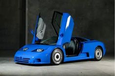 a blue sports car with its doors open