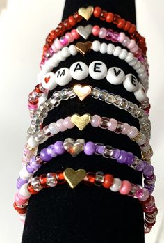 Stacking boho valentine bracelets. You chose the beads, personalization, and heart bead color. These adorable and trendy stacking seed beads bracelets make great gifts. Heart beads are metal and come in silver, gold, or rose color colors. This listing is for ONE bracelet. Pictures are examples. Your choices Style: Plain - Seed beads only With Heart - Seed beads and your choice of heart bead With Name - Seed beads with personalization and red heart beads surrounding the name. Seed bead colors: Al Valentine Bracelets, Seed Beads Bracelets, Bracelet Pictures, Boho Valentine, Valentines Bracelets, Girl Scout Troop, Toddler Gift, Beads Bracelets, Girl Toddler