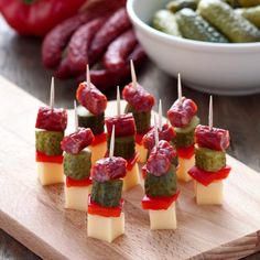 small appetizers with toothpicks and sauces on a cutting board