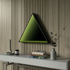 a shelf with books and vases on it in front of a wall mounted triangle