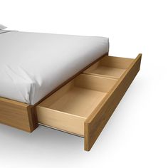 a bed with two drawers underneath it and a white pillow on the top of it