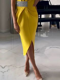 a woman in a yellow dress posing for the camera